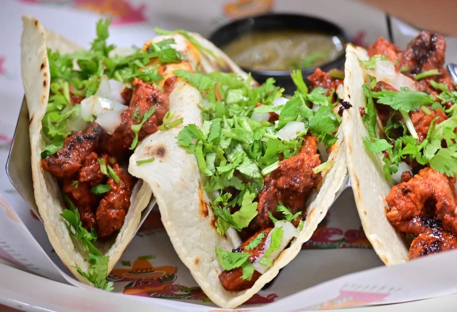 Street tacos topped with onion and cilantro.